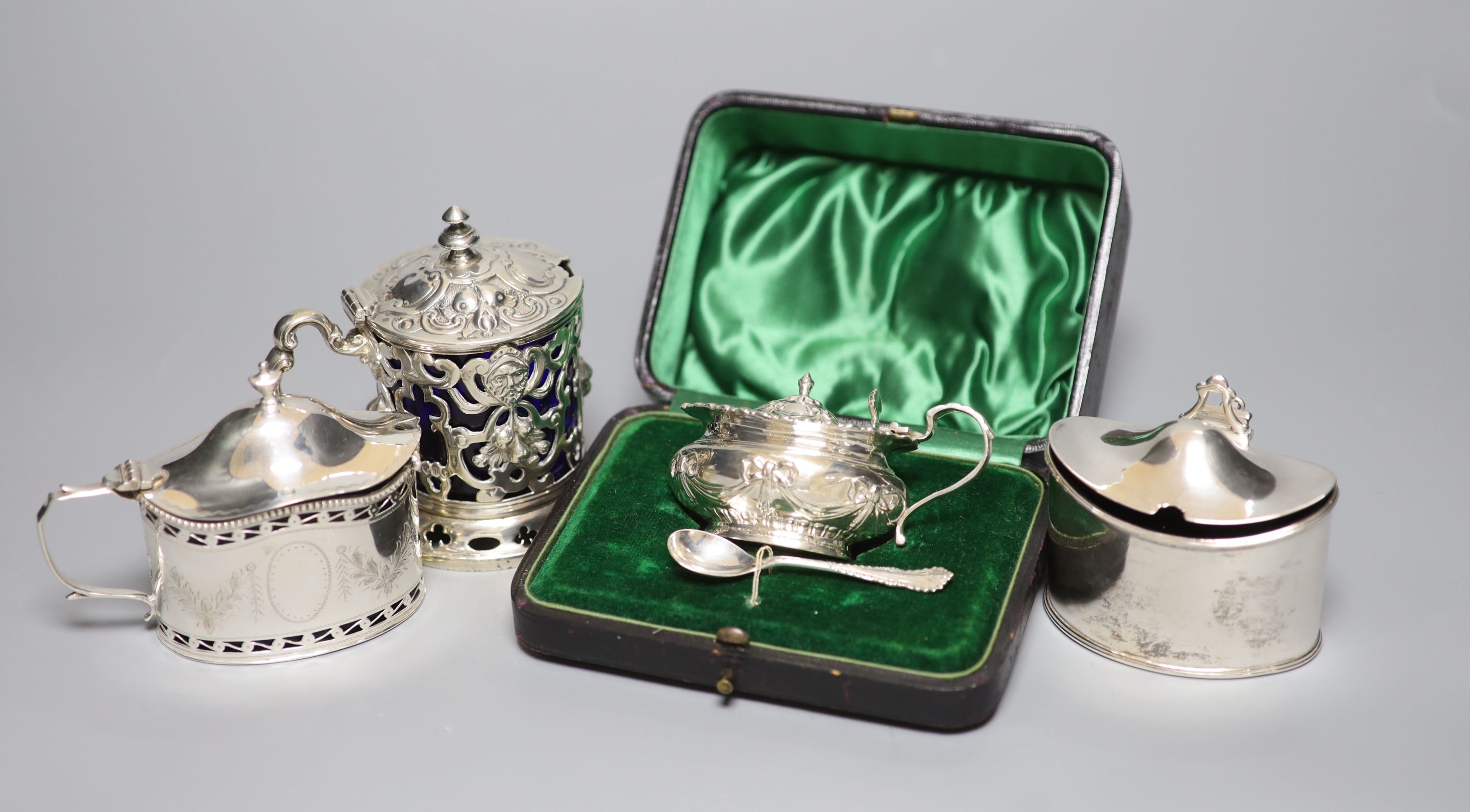 Four mustard pots, various, including a George III oval silver mustard, London 1789, Henry Chawner